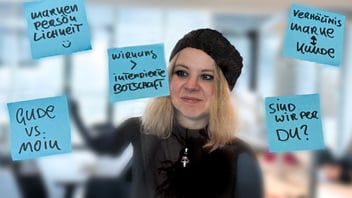 Svenja Kimbel hinter einer Glasscheibe mit Post-its zum Thema Corporate Wording