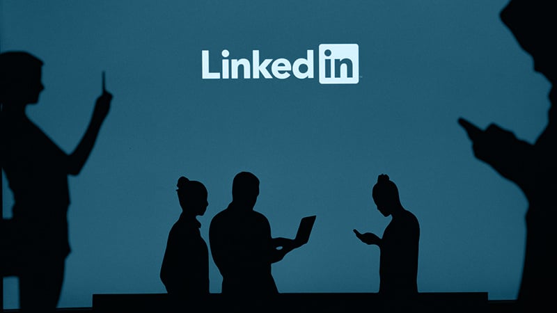 Schematische Darstellung von Personen mit verschiedenen Endgeräten und der Überschrift LinkedIn