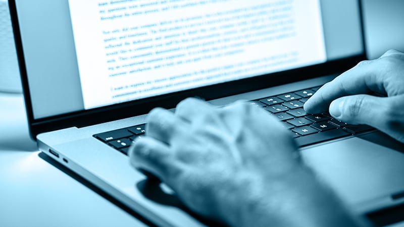 Abbildung eines Laptops mit Händen auf der Tastatur, die gerade einen Text eingeben