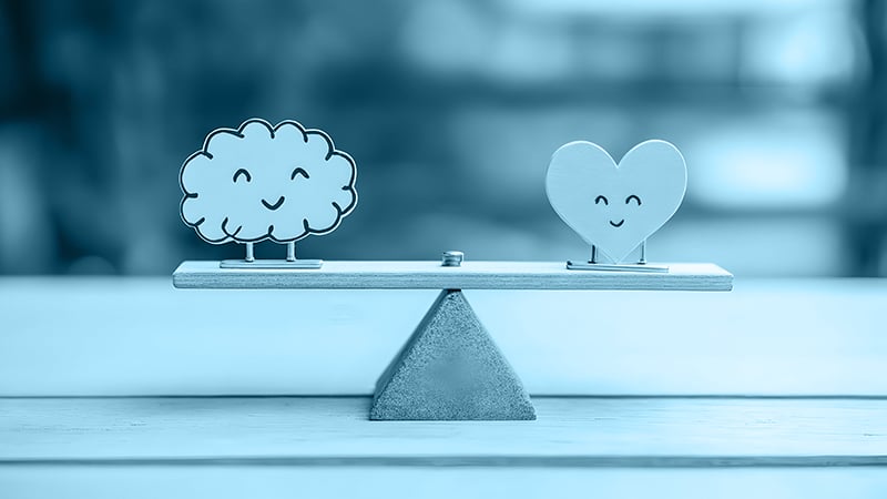 Illustration eines lächelnden Gehirns und Herzens auf einer Waage – Balance zwischen Verstand und Emotion in der PR-Kommunikation.