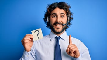 Person mit Headset und einem Post-It mit Fragezeigen