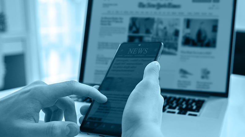 Abbildung Smartphone vor geöffnetem Laptop