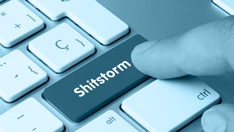 Ausschnitt einer Computertastatur, ein Zeigefinger klickt gerade die Taste "Shitstorm" an